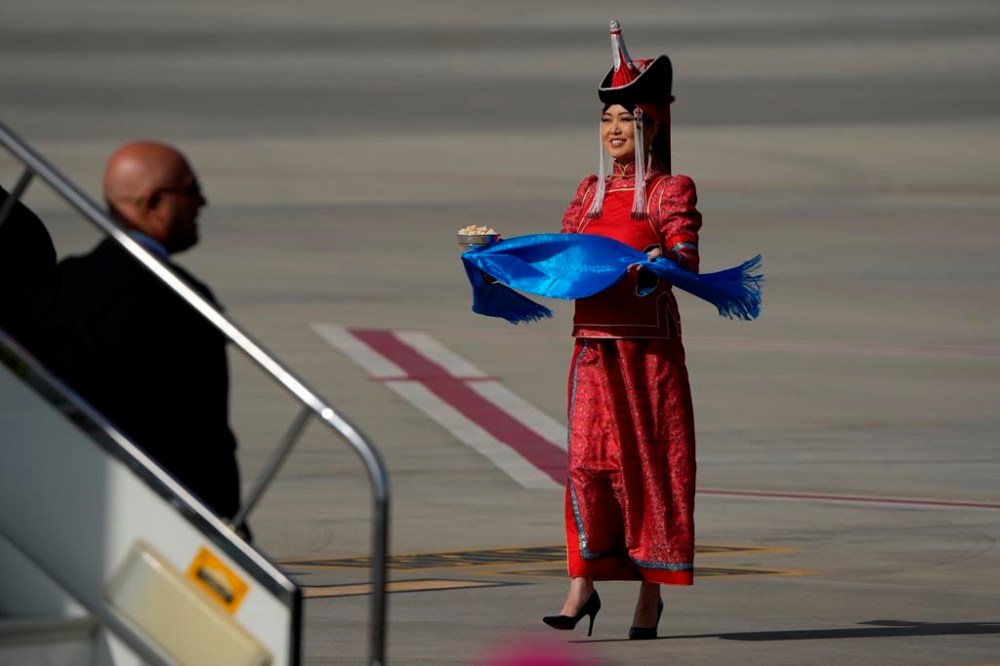 A woman in a traditional Mongolian dress carries Aaruul or Mongolian curd cheese as she waits for Pope Francis at the Ulaanbaatar's International airport Chinggis Khaan, Friday, Sept. 1, 2023. Pope Francis is traveling to Mongolia to encourage one of the world's smallest and newest Catholic communities. It's the first time a pope has visited the Asian country and comes at a time when the Vatican's relations with Mongolia's two powerful neighbors, Russia and China, are once again strained. (AP Photo/Ng Han Guan)