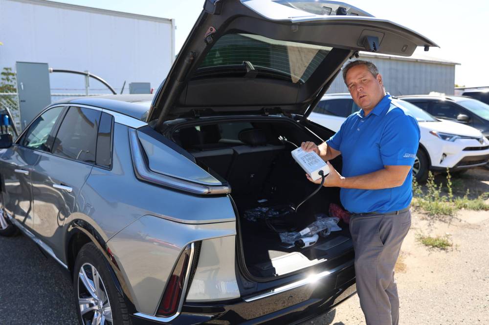 Murray Chevrolet Cadillac Buick GMC Brandon dealer principal Rich Pentney shows charging devices for the EV model of the Cadillac Lyriq. (Abiola Odutola/The Brandon Sun)
