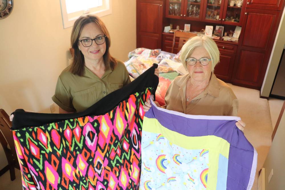Project Linus Westman members Trish Parobec and Bonnie Coombs showcase some of blankets they've collected at Parobec's Brandon home on Aug. 8. The mission statement of Project Linus, which has 45 chapters across Canada, is to provide comfort to children through the creation and distribution of these handmade blankets. (Kyle Darbyson/The Brandon Sun)