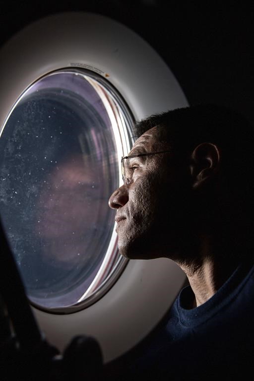 In this photo provided by NASA, astronaut Frank Rubio peers out of a window aboard the SpaceX Dragon Freedom spacecraft docked to the International Space Station. Rubio was observing the SpaceX Dragon Endurance spacecraft, carrying four SpaceX Crew-5 crew members, approach the orbital lab for a docking to the Harmony module's forward port. Rubio and Russian cosmonauts Sergey Prokopyev and Dmitri Petelin are expected to return to Earth on Wednesday, Sept; 27, 2023, after being stuck in space for just over a year after their original capsule was hit by space junk. The 180-day mission turned into a 371-day stay. (NASA via AP)