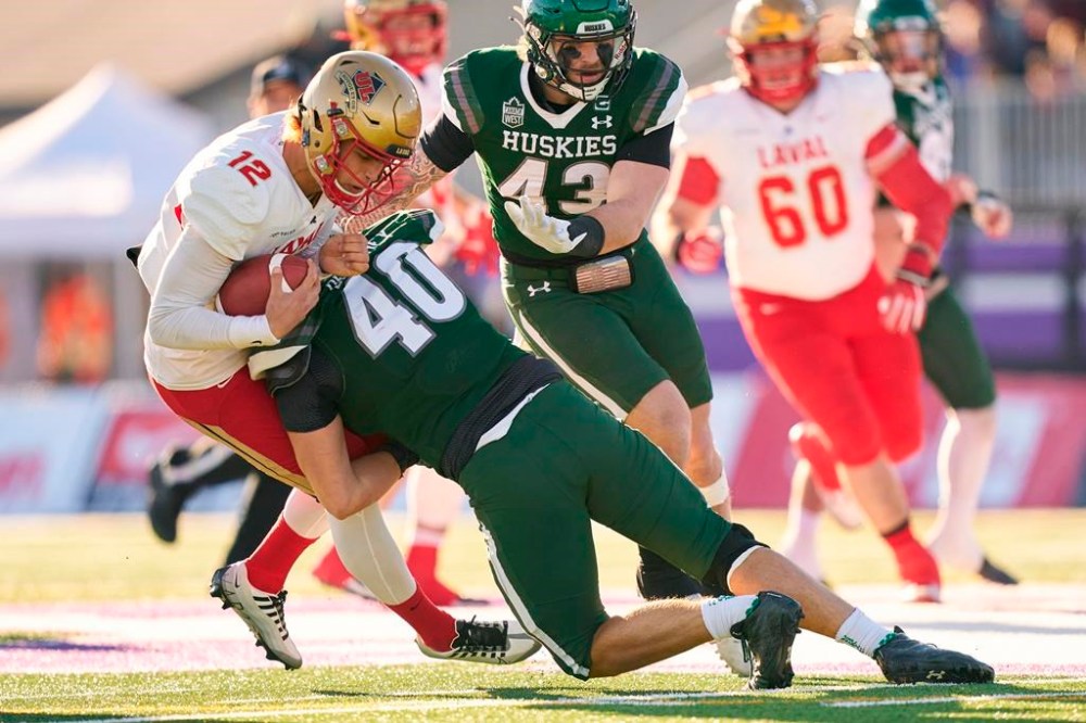 Laval Rouge et Or quarterback Arnaud Desjardins is tackled by Conner Delahey of the Saskatchewan Huskies during the first half of the Vanier Cup in London, Ont., Saturday, Nov. 26, 2022. Canada's governing body of varsity sports is changing its policies to allow students entering universities to be eligible to participate in sports and receive athletic scholarships regardless of their grades.THE CANADIAN PRESS/Geoff Robins