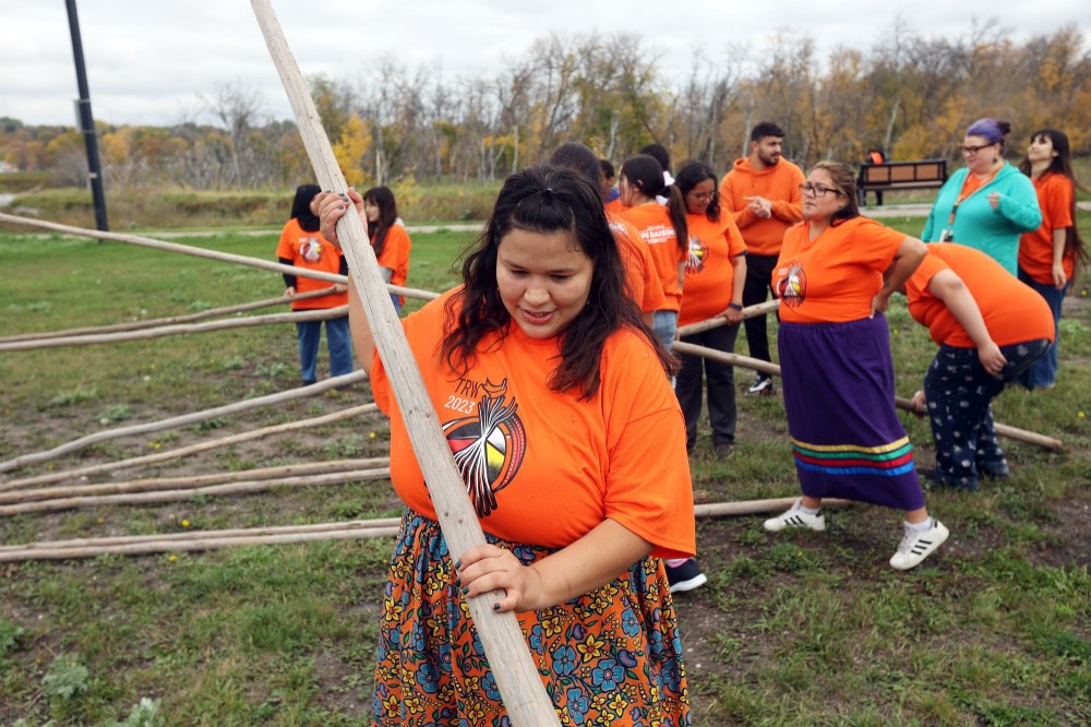 Margaret McKay of Brandon helps raise a teepee. (Tim Smith/The Brandon Sun)