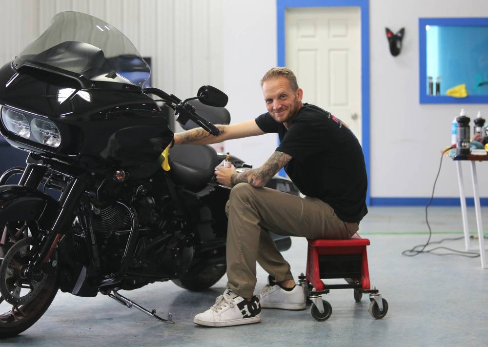 Darren Darvill puts a polishing touch on a Harley Davidson motorcycle that has a ceramic protective coat at his shop on Thursday.