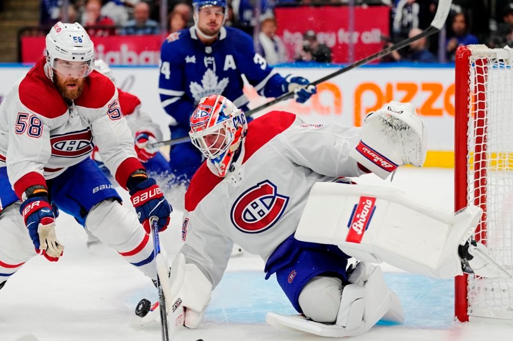 Montreal Canadiens goaltender Jake Allen (34) makes a save against the Toronto Maple Leafs as David Savard (58) defends during second period NHL hockey action in Toronto on Wednesday, October 11, 2023. Savard is out indefinitely with an upper-body injury, the club announced Tuesday. THE CANADIAN PRESS/Frank Gunn