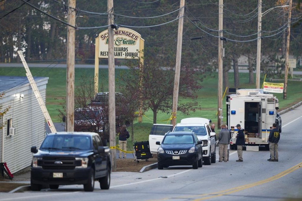 Law enforcemnt officers gather outside Schemengees Bar and Grille in the aftermath of a mass shooting in Lewiston, Maine, Friday, Oct. 27, 2023. Shocked and fearful Maine residents are keeping to their homes for a second night as hundreds of police and FBI agents search intently for Robert Card, a U.S. Army reservist authorities say fatally shot several people at a bowling alley and a bar. (AP Photo/Matt Rourke)