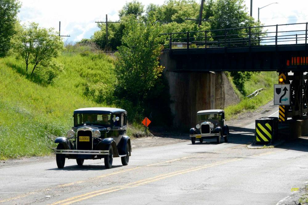 A 1930 Ford Model A followed by a 1928 Ford Model A, heading east on Provincial Trunk Highway 1A at the Kemnay railway underpass just west of Brandon, during last summer's Pine to Prairie Relic Run.