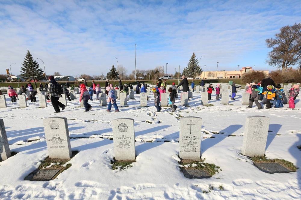 Children from various schools in the Brandon School Division walk along the gravesides of former Canadian Forces service men and women at the Brandon Municipal Cemetery on Friday morning. The children were tasked with placing a poppy on every military stone as a remembrance of their service to their country.