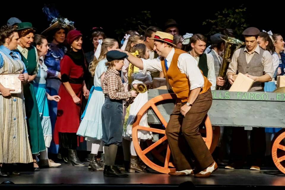 In this scene from “The Music Man,” Harold Hill (played by Brady Chyzyk), the schmoozing salesman, sees how thrilled Winthrop (Xavier McGorman) is when he gets his new instrument. (Virden Empire-Advance)