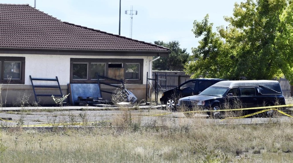 FILE - A hearse and debris can be seen at the rear of the Return to Nature Funeral Home in Penrose, Colo., Oct. 5, 2023. A family filed a lawsuit Monday, Oct. 30, against the Colorado funeral home where 189 decaying bodies were found alleging that the owners, a husband and wife, allowed the remains of their loved ones and to “rot” away while they sent families fake ashes. (Jerilee Bennett/The Gazette via AP, File)