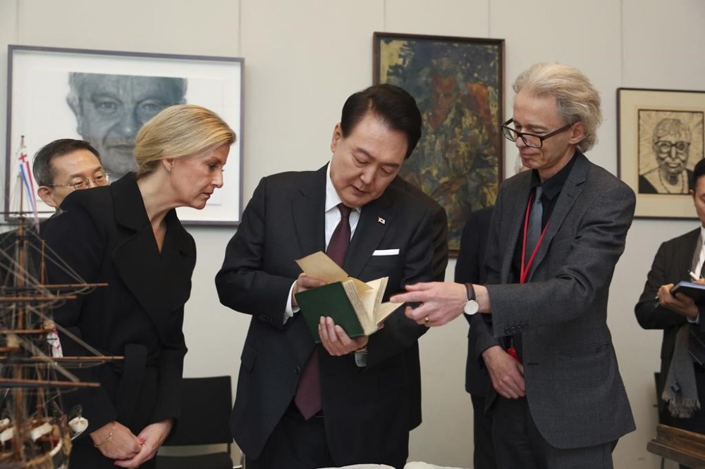 Head of Library at The Royal Society, Keith Moore, right, shows the first edition of Charles Darwin's book