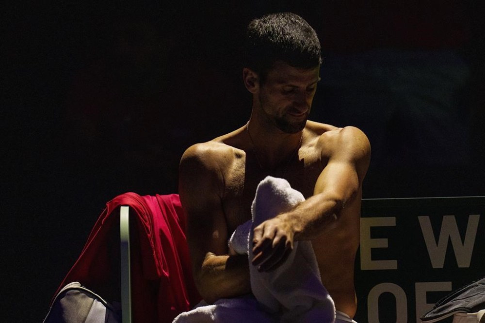 Novak Djokovic of Serbia changes his shirt between sets against Jannik Sinner of Italy during a Davis Cup semi-final tennis match between Italy and Serbia in Malaga, Spain, Saturday, Nov. 25, 2023. (AP Photo/Manu Fernandez)