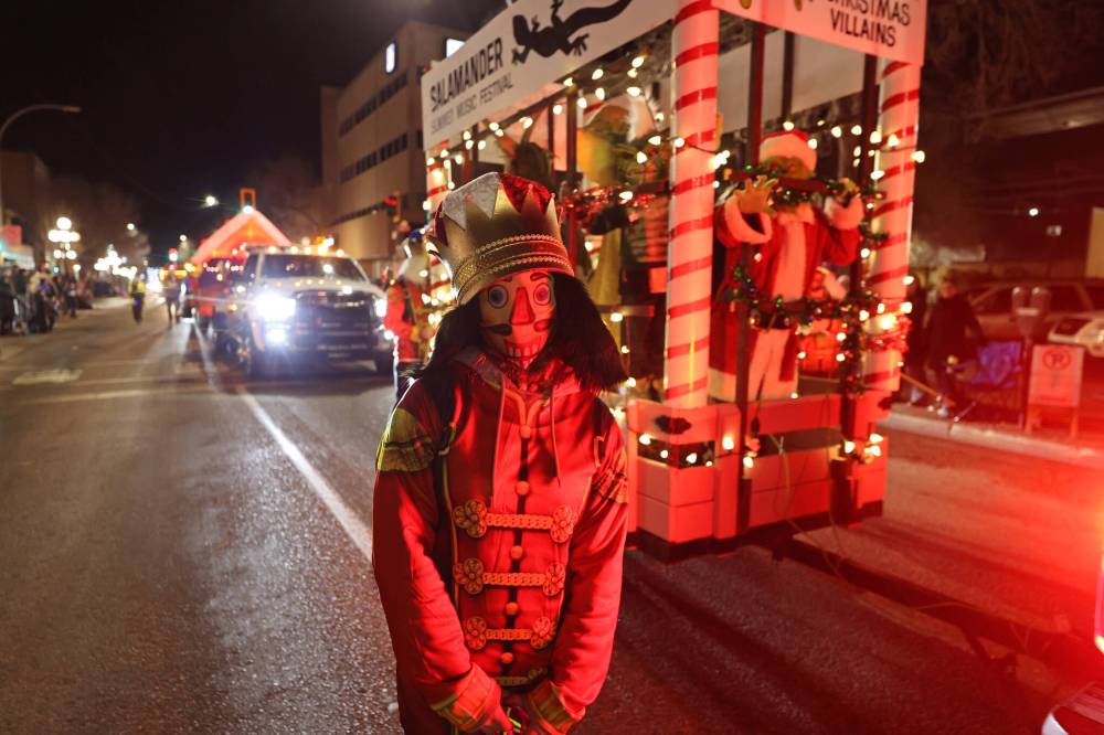 A volunteer dressed as a Christmas nutcracker poses for a photo in front of a float with a Christmas villains theme during the Brandon Santa Parade on Nov. 18. (Abiola Odutola/The Brandon Sun)