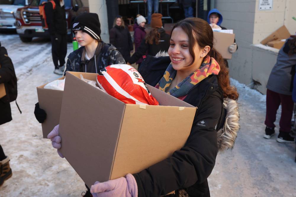 Grade 7-8 students from Oak Lake Community School help load hampers into waiting vehicles at the Brandon & Westman Christmas Cheer Registry. (File)