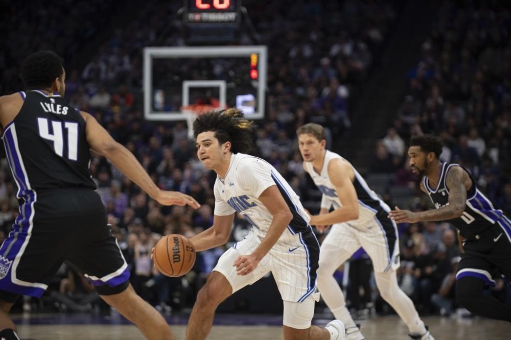 Orlando Magic guard Anthony Black (0) brings the ball up court as Sacramento Kings forward Trey Lyles (41) defends in the first quarter of an NBA basketball game in Sacramento, Calif., Wednesday, Jan. 3, 2024. (AP Photo/José Luis Villegas)