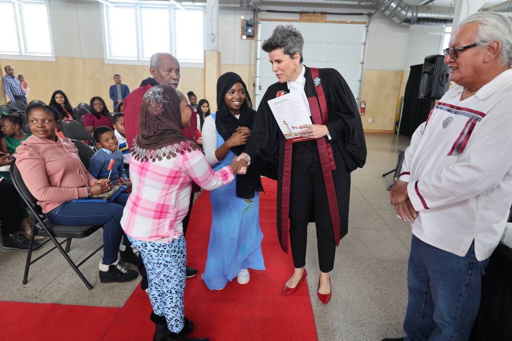 Ten-year-old Fatna Mohammed from Eritrea shakes hands with Citizenship Judge Suzanne Carriere after being sworn in as a Canadian citizen on Oct. 26. Columnist Marina M. Doucerain asks whether integration leads to emotional well-being for immigrants, or vice versa. (File)