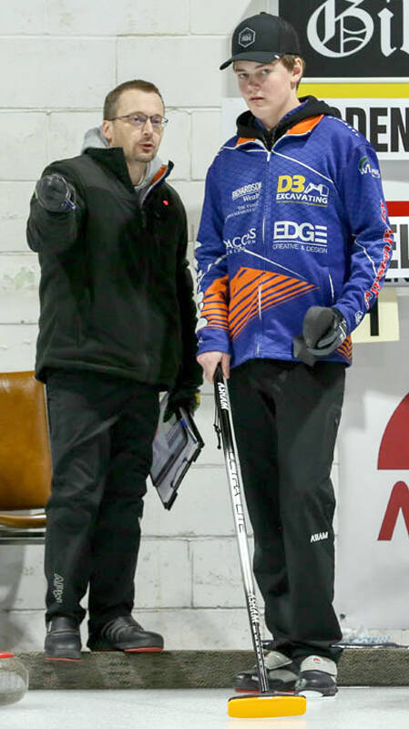 Altona skip Rylan Campbell of Brandon discusses strategy at the U18 provincials held in Selkirk with coach Sheldon Zacharias. (Photo courtesy CurlManitoba)