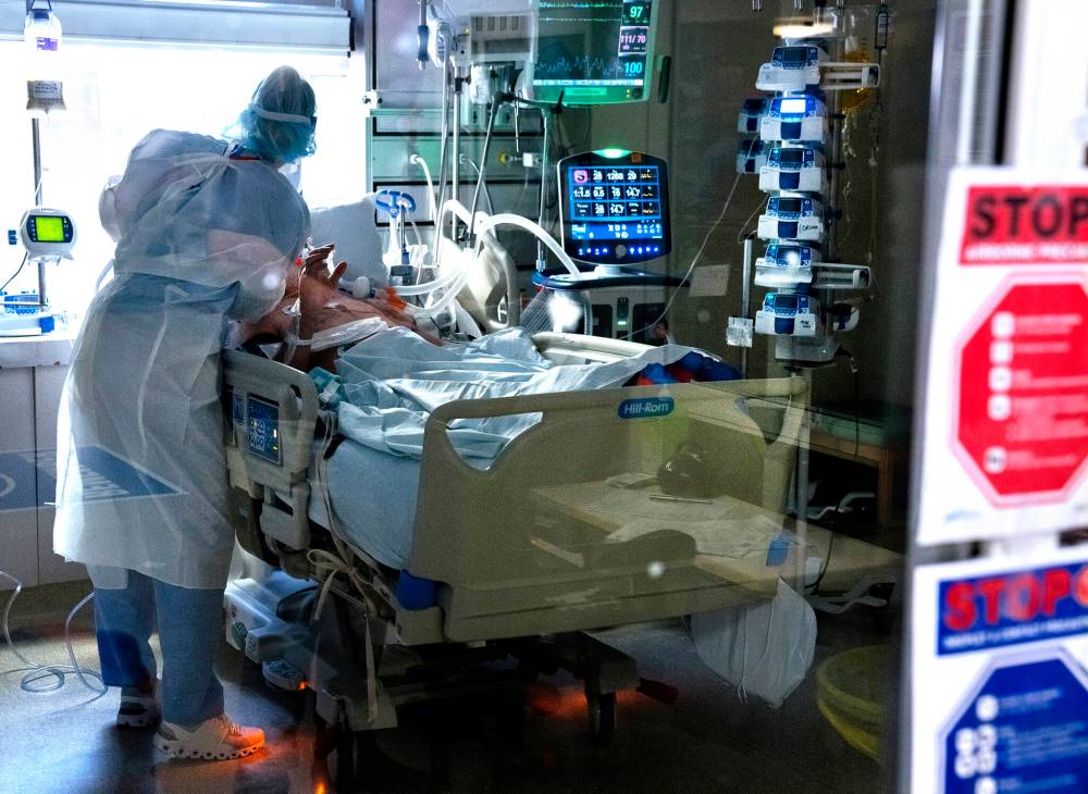 A registered nurse works with a patient in the intensive care unit at a Halifax health centre. The nation-wide shortage of nurses continues to take its toll on Manitoba, with nurses urged to work more overtime than ever, write the presidents of the provincial and national nurses unions. (The Canadian Press)