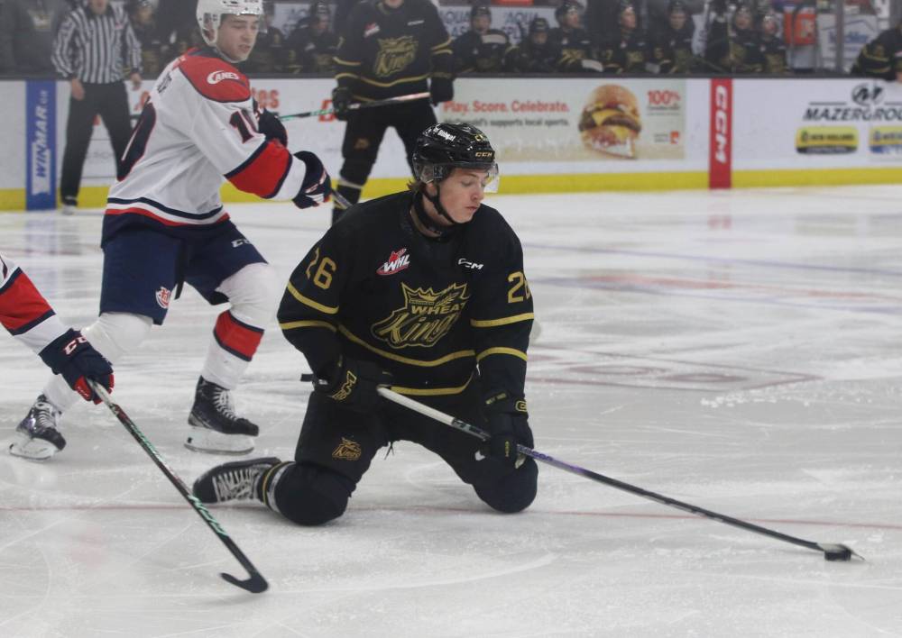 Brandon Wheat Kings forward Nick Johnson (26) continues to control the puck after being knocked to the ice as Lethbridge Hurricanes forward Dylan Sydor (10) looks on. Johnson is a power forward who has the ability to put up some points. (Photos by Perry Bergson/The Brandon Sun)