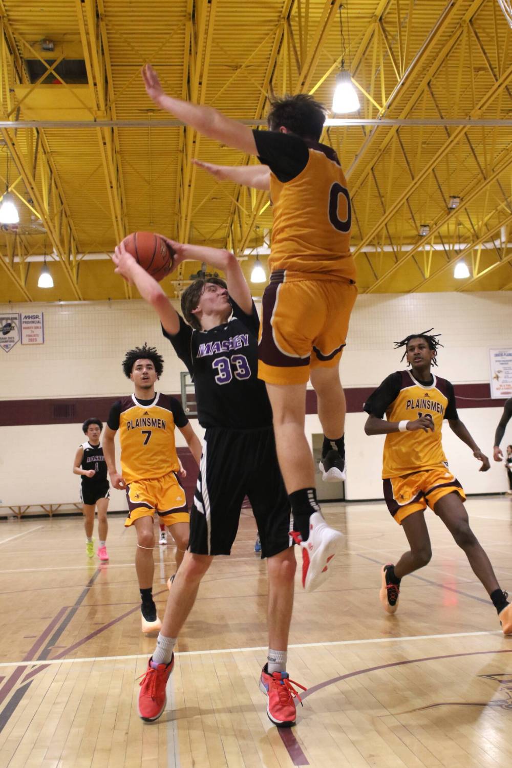Vikings Josh Romanik pump fakes to get Plainsmen guard Ayden Bone in the air.