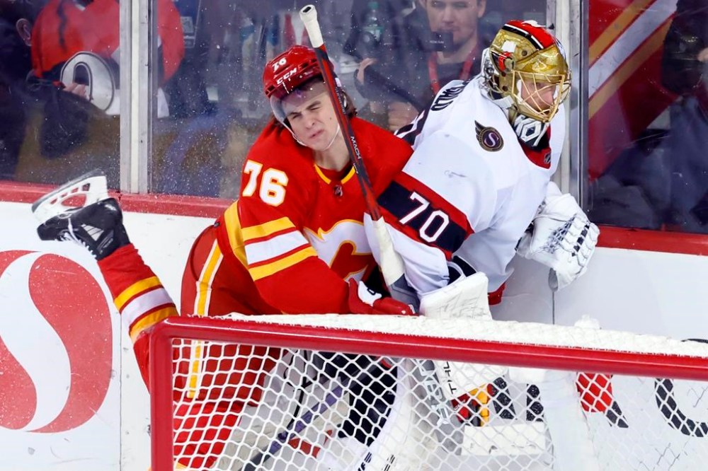 Calgary Flames' Martin Pospisil, left, runs into Ottawa Senators goalie Joonas Korpisalo during second period NHL hockey action in Calgary, Tuesday, Jan. 9, 2024. THE CANADIAN PRESS/Larry MacDougal
