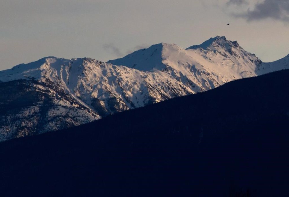 A helicopter flies past a mountain near McBride, B.C., on Saturday January 30, 2016. Environment Canada is warning parts of northern British Columbia to expect wind chill values as cold as -50 C for at least the rest of the week. THE CANADIAN PRESS/Darryl Dyck
