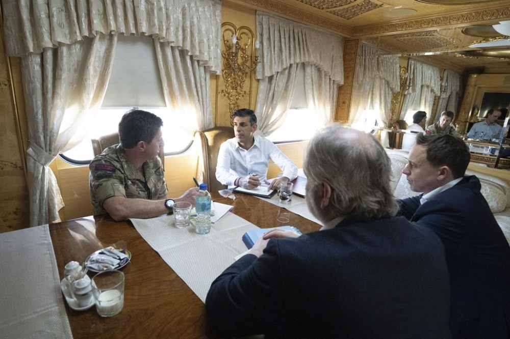 Britain's Prime Minister Rishi Sunak, top right, speaks with Vice Chief of the Defence Staff Major General Gwyn Jenkins, left, on a train travelling through Ukraine as he heads to meet with President Volodymyr Zelensky after announcing a major new package of £2.5 billion in military aid to the country over the coming year, near Kyiv, Ukraine, Friday Jan. 12, 2024. (Stefan Rousseau/Pool via AP)