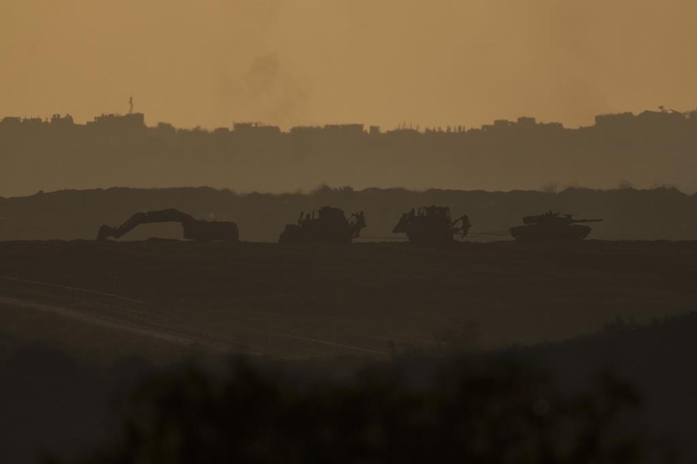 An Israeli tank and bulldozers move inside the Gaza Strip as seen from southern Israel, Tuesday, Jan. 16, 2024. (AP Photo/Leo Correa)