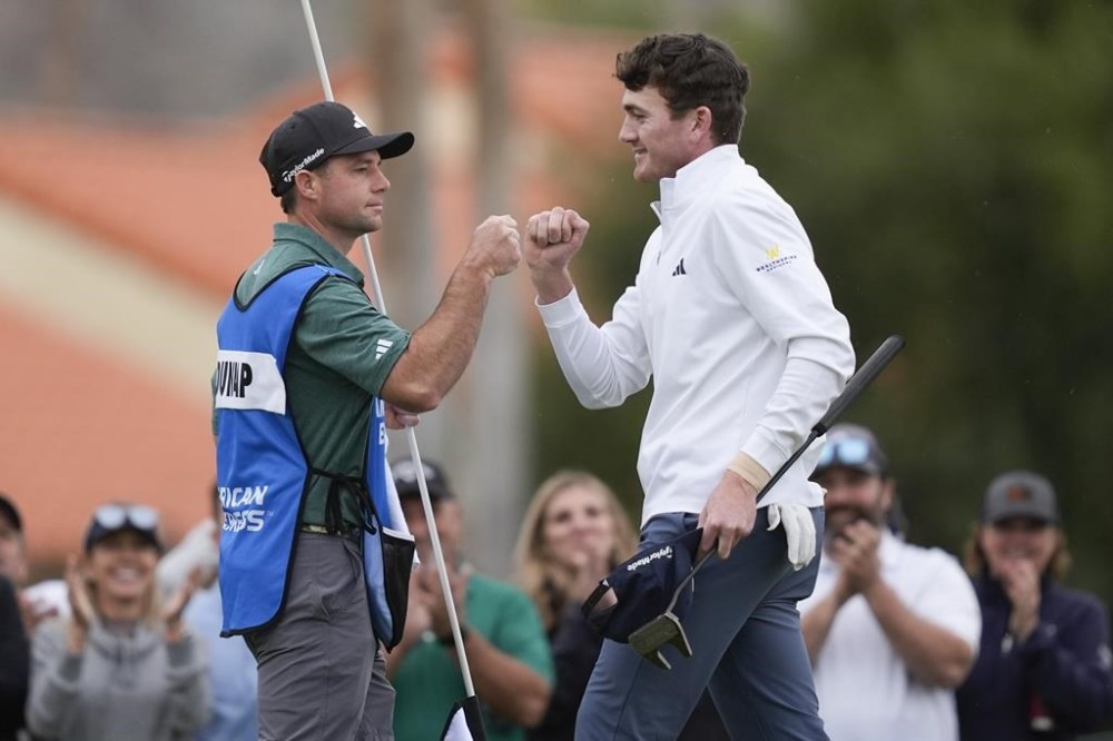 Nick Dunlap, right, bumps fists with his caddie on the ninth green at the La Quinta Country Club course during the third round of The American Express golf tournament Saturday, Jan. 20, 2024, in La Quinta, Calif. (AP Photo/Ryan Sun)