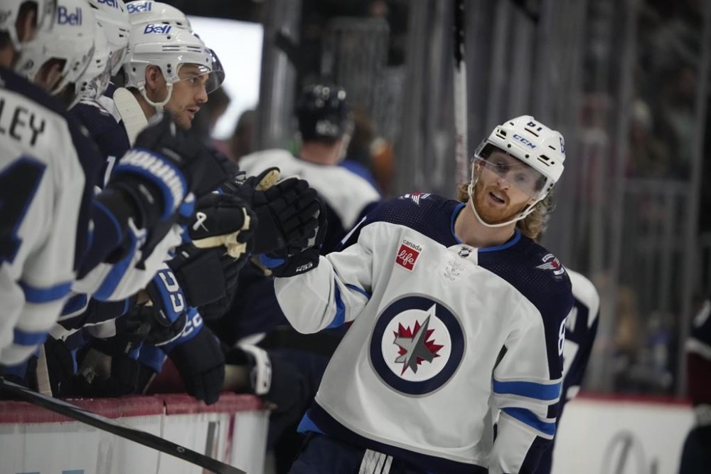 Winnipeg Jets left wing Kyle Connor (81) is congratulated as he passes the team box after scoring a goal against the Colorado Avalanche n the third period of an NHL hockey game on Thursday, Dec. 7, 2023, in Denver. Connor has been added to the roster for the NHL's upcoming All-Star Weekend in Toronto. THE CANADIAN PRESS/AP-David Zalubowski