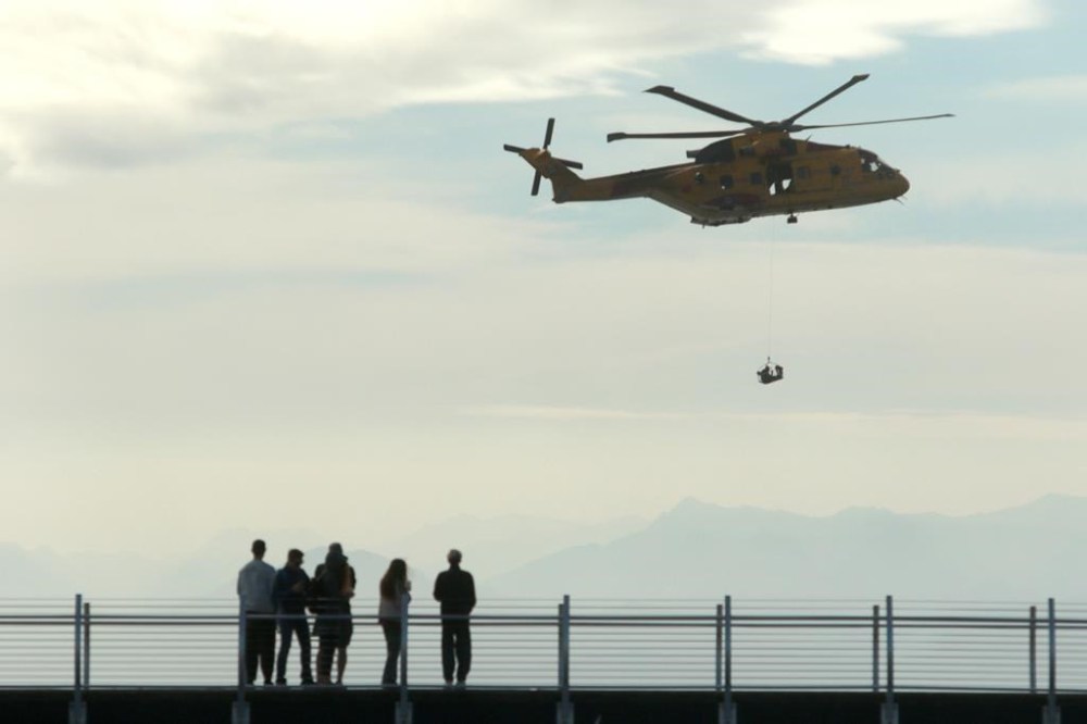 People look on as the AgustaWestland CH-149 Cormorant helicopter demonstrates a search and rescue operation during the Defence on the Dock at the Ogden Point Breakwater District in Victoria, Sunday, Sept. 17, 2023. Officials have confirmed that a helicopter crashed on Terrace in B.C. Monday afternoon. THE CANADIAN PRESS/Chad Hipolito
