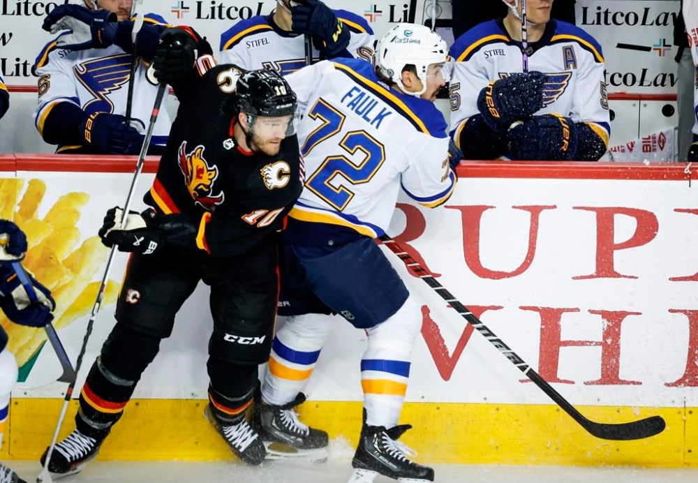 St. Louis Blues defenceman Justin Faulk (72) checks Calgary Flames forward Jonathan Huberdeau (10) during second period NHL hockey action in Calgary, Tuesday, Jan. 23, 2024. THE CANADIAN PRESS/Jeff McIntosh