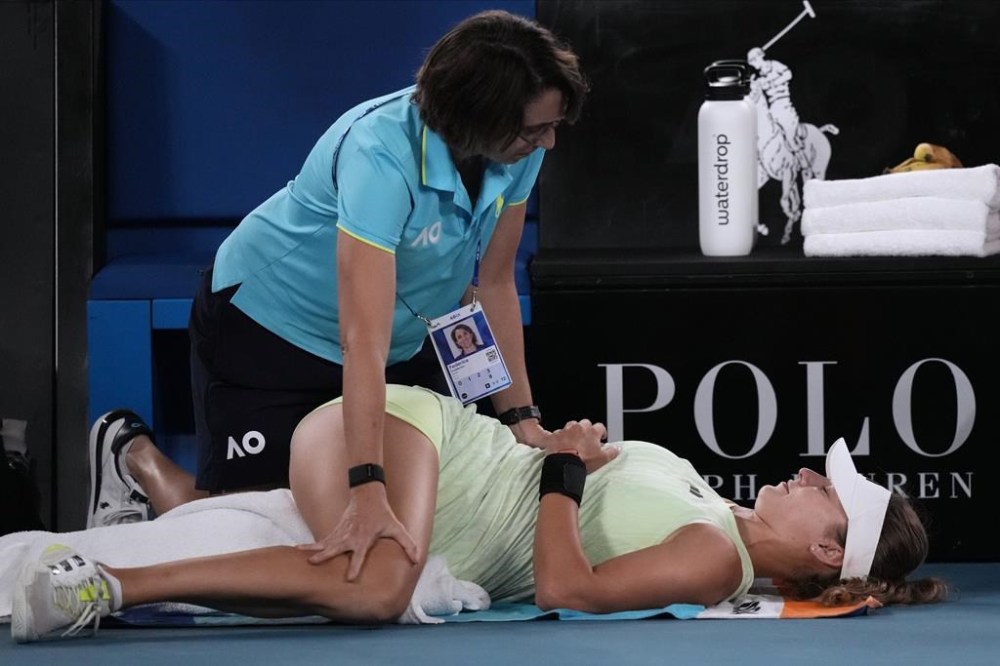 Anna Kalinskaya of Russia receives treatment from a trainer during her quarterfinal against Zheng Qinwen of China at the Australian Open tennis championships at Melbourne Park, Melbourne, Australia, Wednesday, Jan. 24, 2024. (AP Photo/Louise Delmotte)