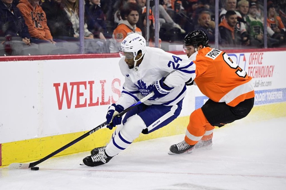 Toronto Maple Leafs' Wayne Simmonds, left, plays the puck past Philadelphia Flyers' Ivan Provorov during the first period of an NHL hockey game, Sunday, Jan. 8, 2023, in Philadelphia. After 15 hard-nosed NHL seasons where he filled the net and threw plenty of fists, Simmonds has called time on his playing career. THE CANADIAN PRESS/AP-Derik Hamilton