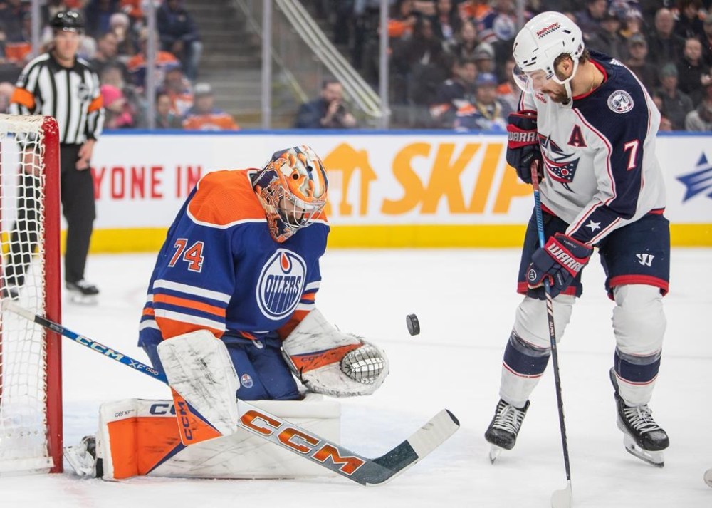 Columbus Blue Jackets' Sean Kuraly (7) gets stopped by Edmonton Oilers goalie Stuart Skinner (74) during first period NHL action in Edmonton, on Tuesday, January 23, 2024. The Oilers are on a 15-game winning streak, and Skinner is on an 11-game personal win streak that surpassed Fuhr’s team mark for consecutive victories in goal. THE CANADIAN PRESS/Amber Bracken
