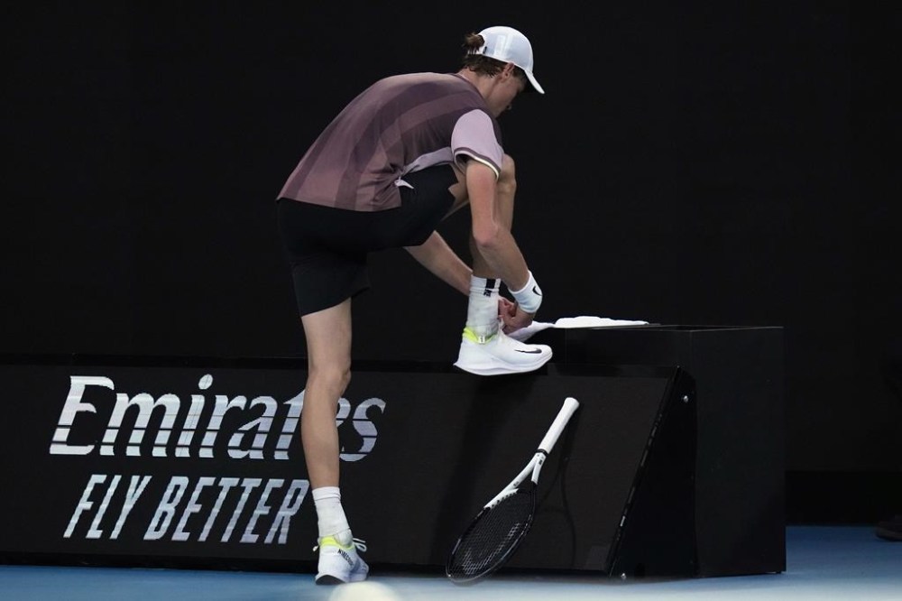 Jannik Sinner of Italy ties his shoe laces during his match against Daniil Medvedev of Russia in the men's singles final at the Australian Open tennis championships at Melbourne Park, in Melbourne, Australia, Sunday, Jan. 28, 2024. (AP Photo/Andy Wong)