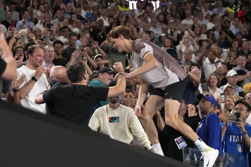 Jannik Sinner of Italy climbs into his players box as he celebrates his victory over Daniil Medvedev of Russia during the men's singles final at the Australian Open tennis championships at Melbourne Park, in Melbourne, Australia, Sunday, Jan. 28, 2024. (AP Photo/Alessandra Tarantino)