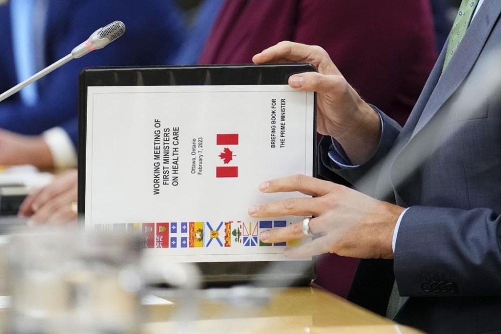 Prime Minister Justin Trudeau flips open a briefing book titled