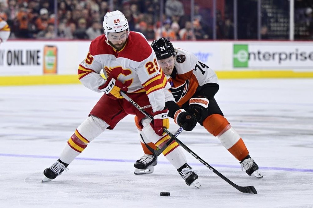 Lawyers for Dillon Dube say the Calgary Flames forward has been charged with sexual assault by police in London, Ont., in connection to allegations involving Canada's 2018 world junior hockey team. Dube, left, skates the puck past Philadelphia Flyers' Owen Tippett during the third period of an NHL hockey game, in Philadelphia, Saturday, Jan. 6, 2024. THE CANADIAN PRESS/AP-Derik Hamilton