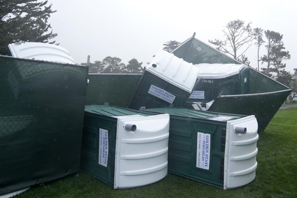 Fallen portable toilets are shown at Pebble Beach Golf Links before the scheduled final round of the AT&T Pebble Beach National Pro-Am golf tournament in Pebble Beach, Calif., Sunday, Feb. 4, 2024. The final round of the AT&T Pebble Beach Pro-Am has been postponed until Monday. (AP Photo/Ryan Sun)