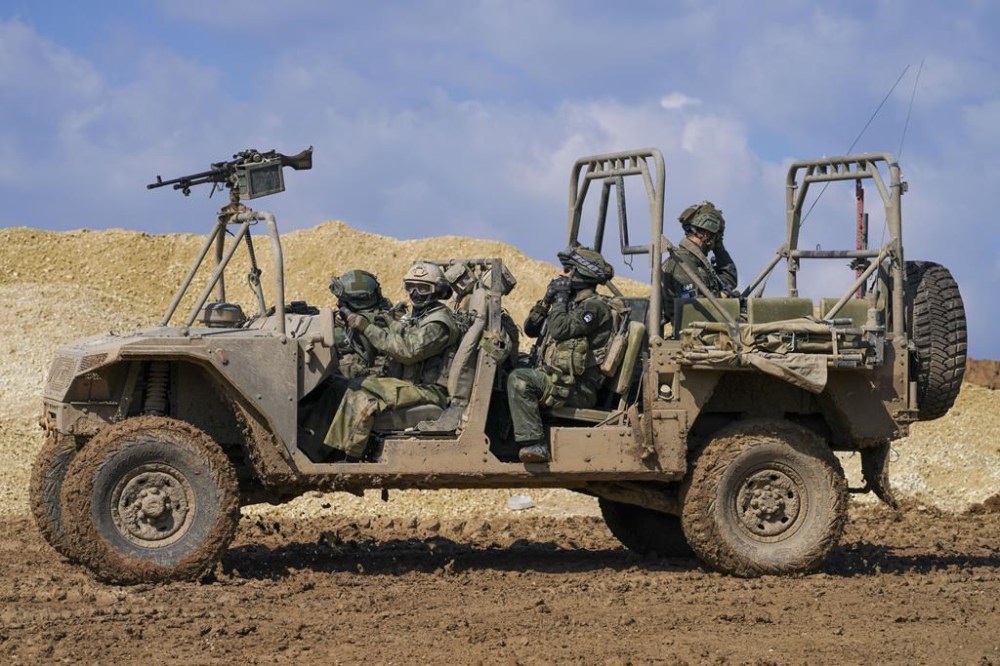 Israeli soldiers drive near the border with the Gaza Strip, as seen in southern Israel, Tuesday, Feb. 6, 2024. (AP Photo/Tsafrir Abayov)