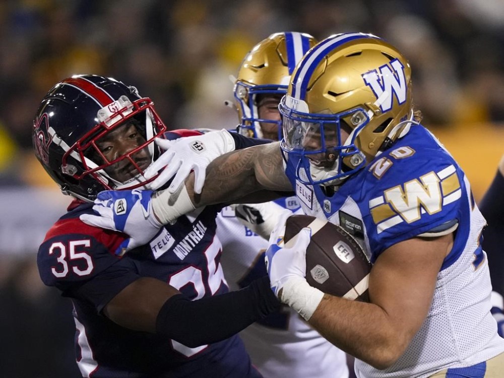 Winnipeg Blue Bombers running back Brady Oliveira (20) scores a touch down as he stiff arms Montreal Alouettes defensive back Reggie Stubblefield (35) during the first half of football action at the 110th CFL Grey Cup in Hamilton, Ont., on Sunday, November 19, 2023. THE CANADIAN PRESS/Nathan Denette