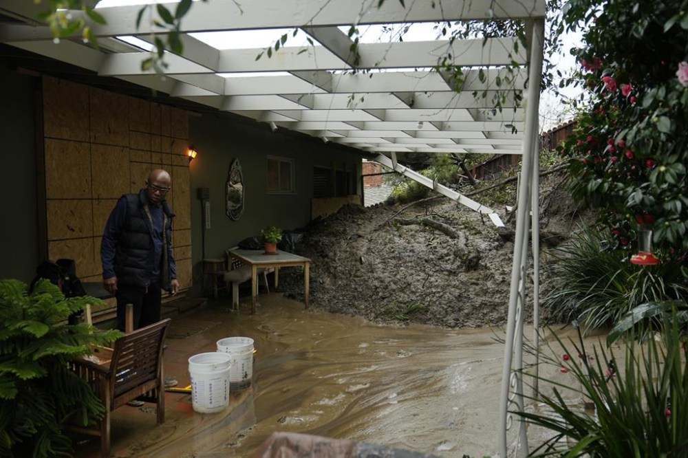 Prentice Sinclair Smith a friend of home owner Dion Peronneau says she was awoken by the sound of cracking around 4 a.m. early morning Monday, as mudflow forced its way into her home in the Baldwin Hills area of Los Angeles, Tuesday, Feb. 6, 2024. (AP Photo/Damian Dovarganes)