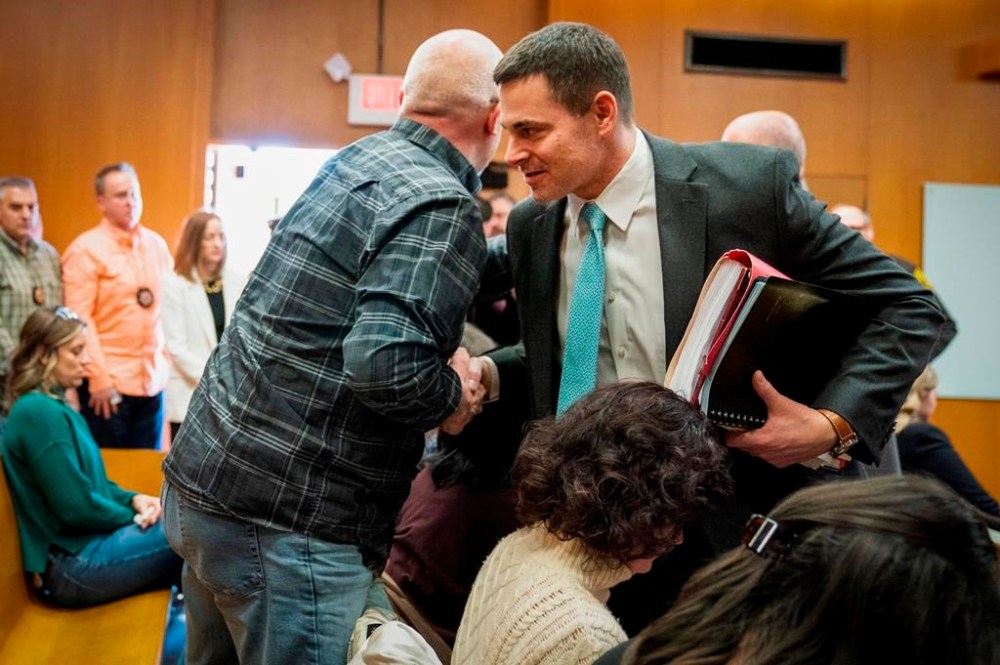 Craig Shilling, left, father of Justin Shilling who was killed in the Oxford School shooting in 2021, shakes hands with Oakland County Assistant Prosecutor Mark Keast after Jennifer Crumbley, mother of shooter Ethan Crumbley, was found guilty on four counts of involuntary manslaughter in the Oakland County courtroom of Cheryl Matthews on Tuesday, Feb. 6, 2024 in Pontiac, Mich. (Mandi Wright/Detroit Free Press via AP, Pool)