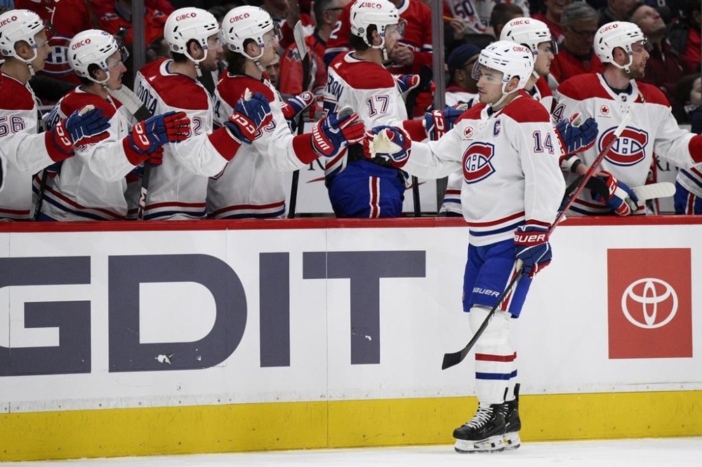 Montreal Canadiens center Nick Suzuki (14) celebrates his second goal of the game against the Washington Capitalsduring the first period of an NHL hockey game, Tuesday, Feb. 6, 2024, in Washington. (AP Photo/Nick Wass)