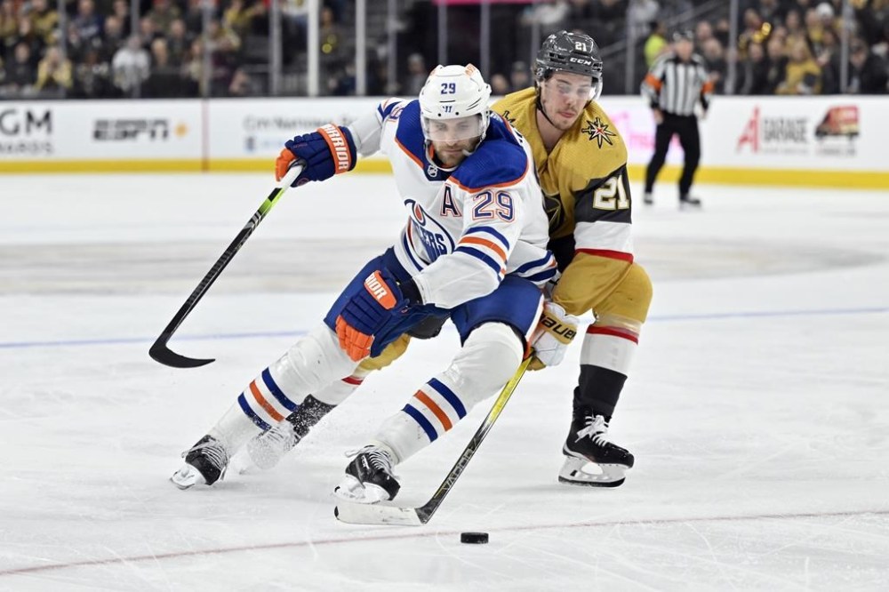 Edmonton Oilers center Leon Draisaitl (29) and Vegas Golden Knights center Brett Howden (21) battle for the puck during the second period of an NHL hockey game Tuesday, Feb. 6, 2024, in Las Vegas. (AP Photo/David Becker)
