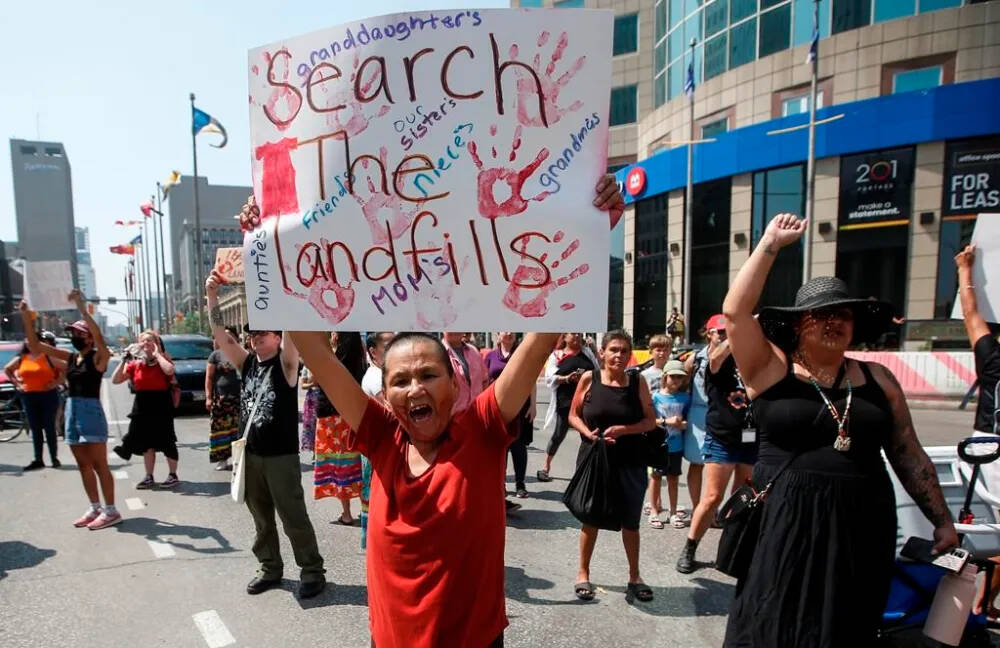 The Assembly of Manitoba Chiefs is to discuss details today about a report into the logistics of searching a Winnipeg-area landfill for the remains of two slain First Nations women. Family and supporters are shown here gathered to protest all levels of governments’ lack of action in funding a search of Winnipeg’s landfills for missing women at Portage and Main in Winnipeg on Aug. 3, 2023. (The Canadian Press)
