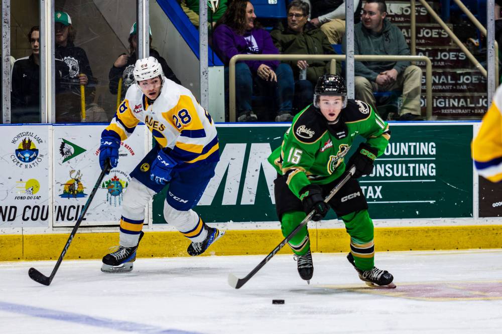 Brayden Dube, shown with the puck as Saskatoon Blades forward Lukas Hansen of Winnipeg looks on, has a bigger role with the Prince Albert Raiders this season. (Mark Peterson/Prince Albert Raiders)