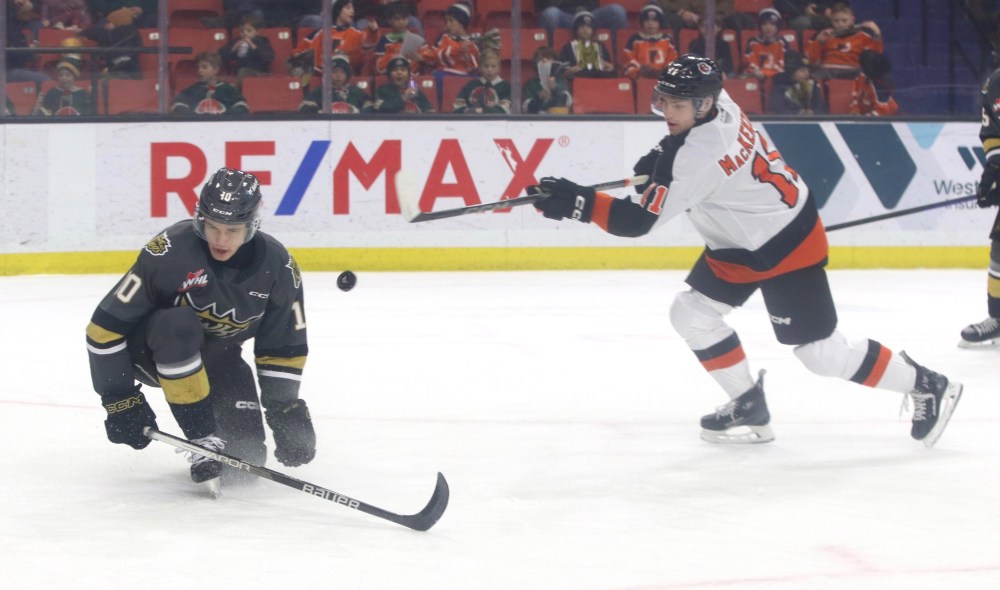 The puck bounces off Brandon Wheat Kings forward Caleb Hadland (10) after he blocked a shot by Medicine Hat Tigers forward Tyler MacKenzie (11) during the first period in Western Hockey League action at Westoba Place on Sunday. (Perry Bergson/The Brandon Sun)