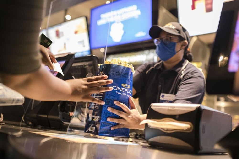 Cineplex Inc. reported a fourth-quarter loss $9 million compared with a profit of $10.2 million a year earlier as its revenue edged higher. A customer is served at a Cineplex theatre in Toronto on Wednesday, Aug. 26, 2020. THE CANADIAN PRESS/Christopher Katsarov