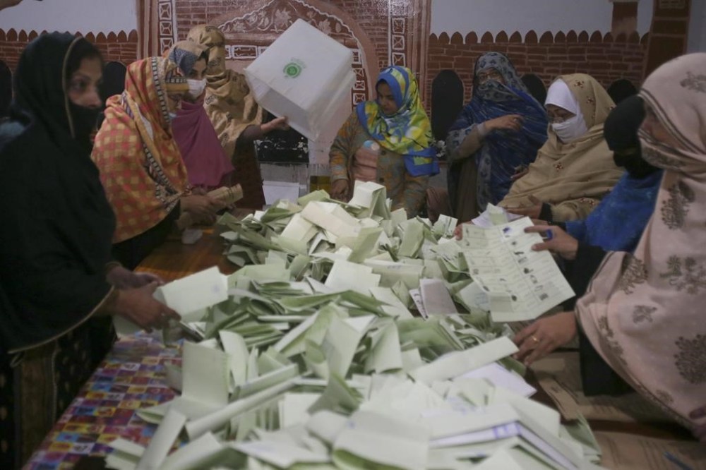 Members of polling staff count the votes after the polls closed for parliamentary elections, in Peshawar, Pakistan, Thursday, Feb. 8, 2024. (AP Photo/Muhammad Sajjad)